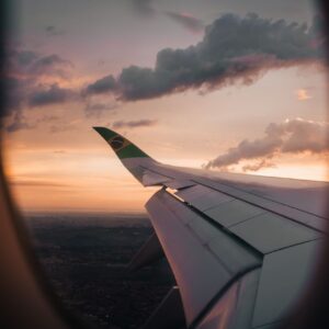 View from airplane window showing wing against a Brazilian sunset sky.