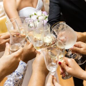 Hands toasting with champagne glasses at a wedding celebration